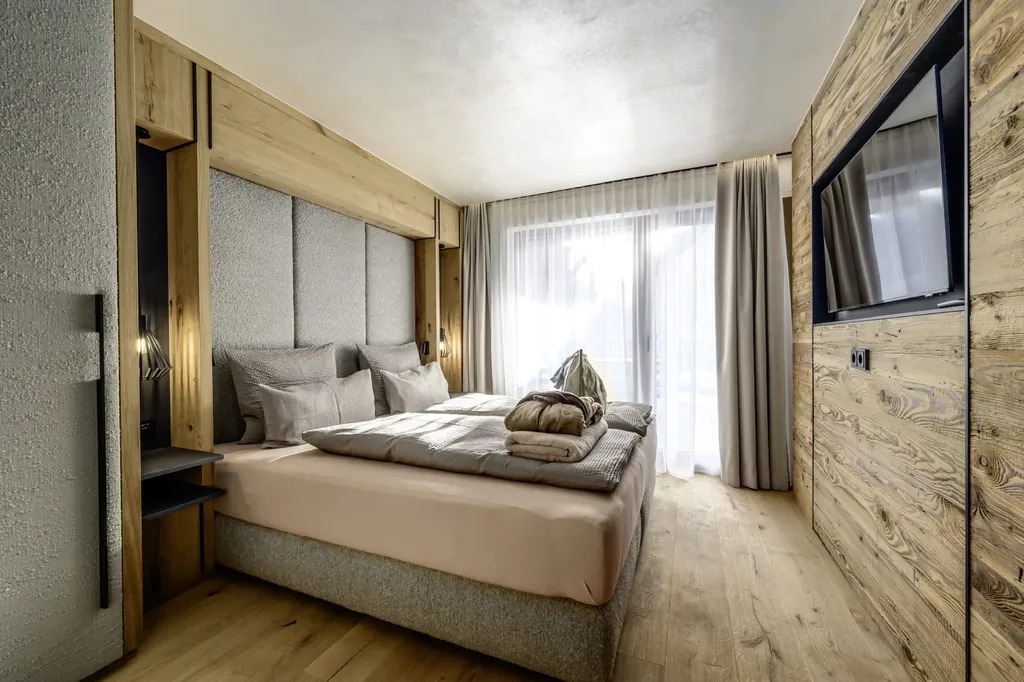 Schlafzimmer im The Peak Sölden mit Holzverkleidung und großem Fernseher