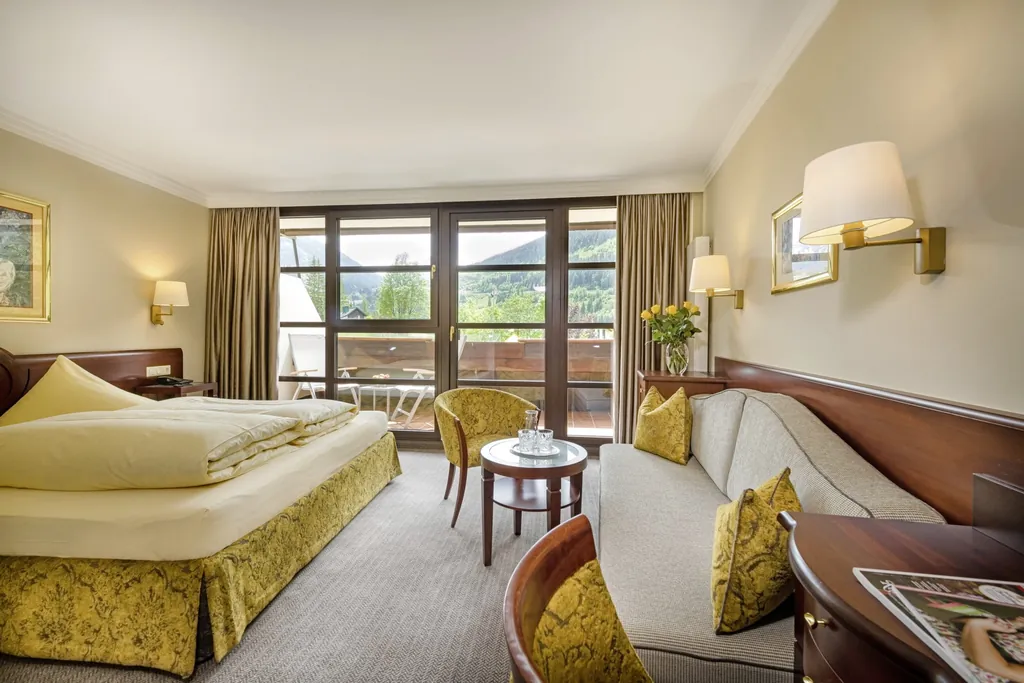 Doppelzimmer im Hotel Sonngastein mit gelber Bettumrandung und gelb bezogenen Stühlen