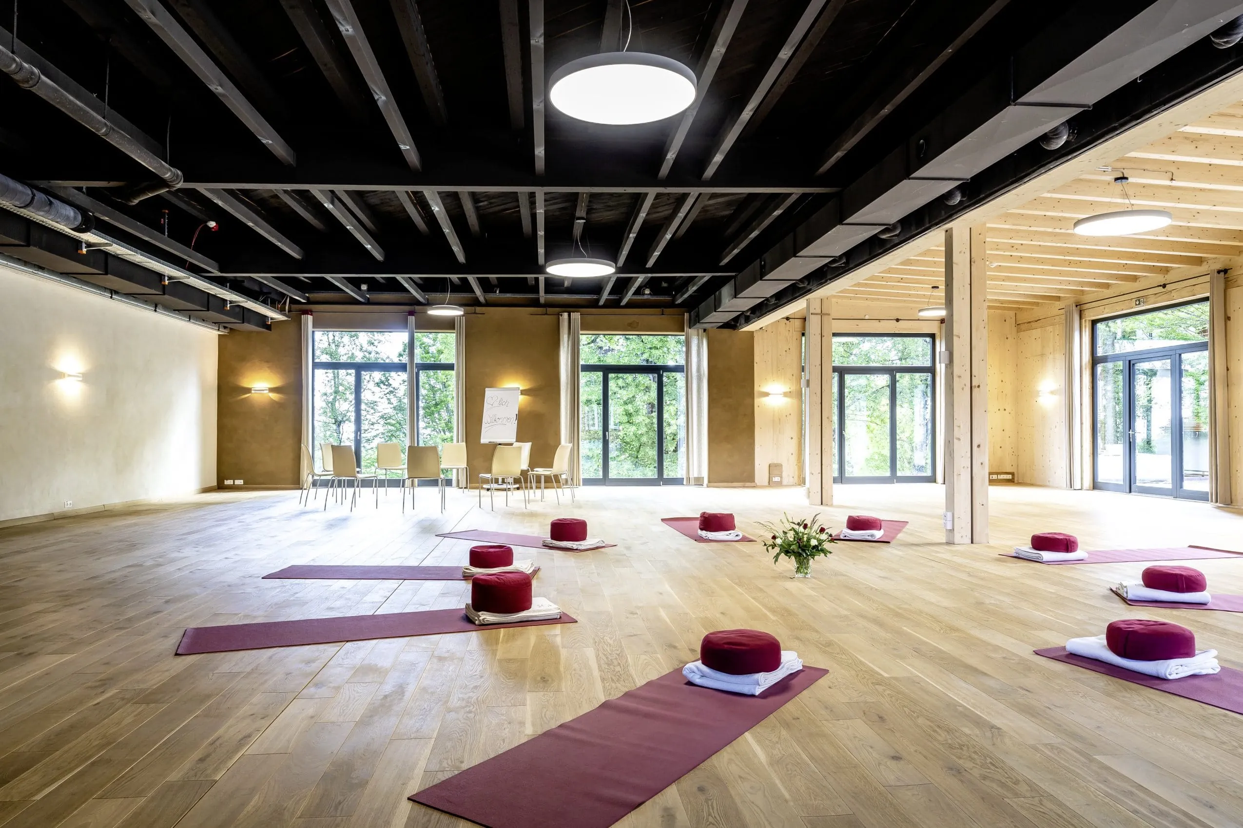 Yogamatten in gro&szlig;em Saal im SEINZ Wisdom Resort mit schwarzer Industriedecke