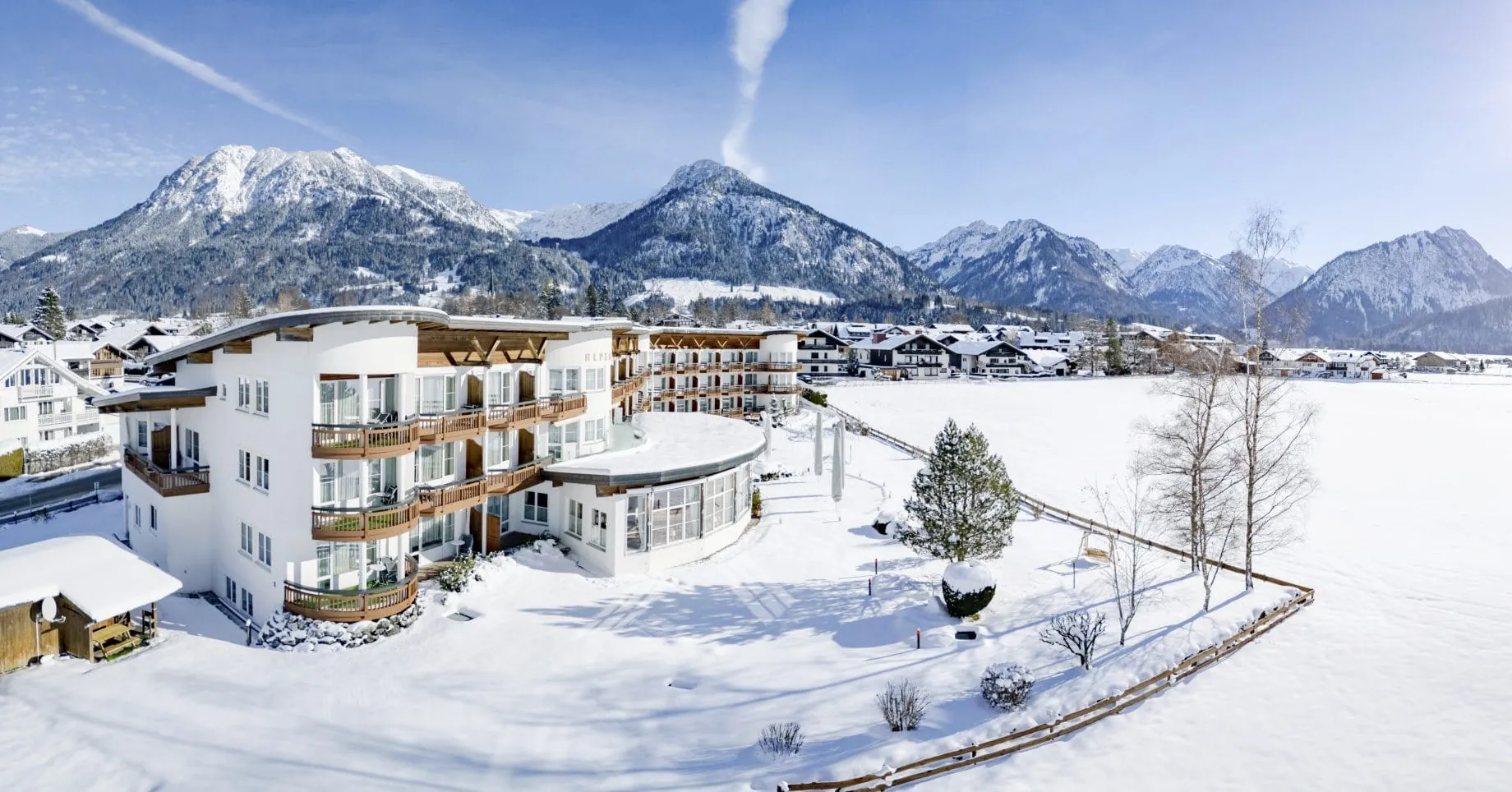 Außenansicht Alpenhof Oberstdorf im Winter mit Blick auf die verschneiten Berge