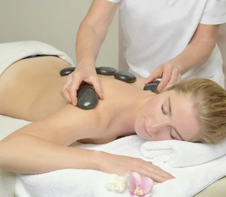 blonde Frau erhält Hot Sone-Massage im Alpenhof Oberstdorf