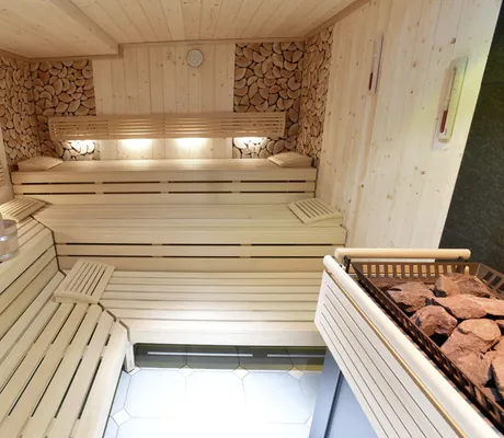 Blick in die Sauna im Alpenhof Oberstdorf mit beleuchteter Rückwand