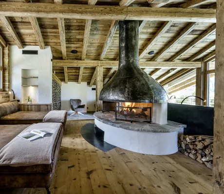 braune Leder-Ruheliegen im Ruheraum des Hotel Post Lermoos vor offenem prasselnden Kamin