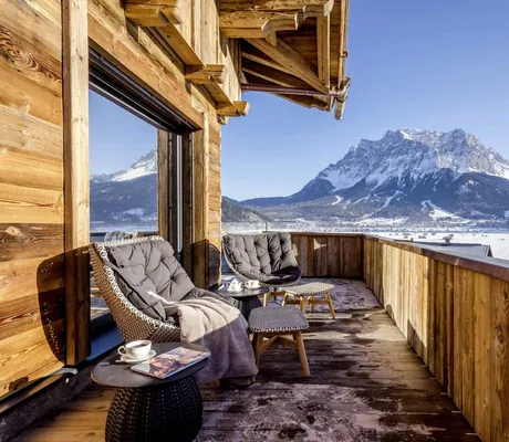 zwei Korbsessel mit Decken auf dem Balkon im Hotel Post Lermoos mit Blick auf die Zugspitze