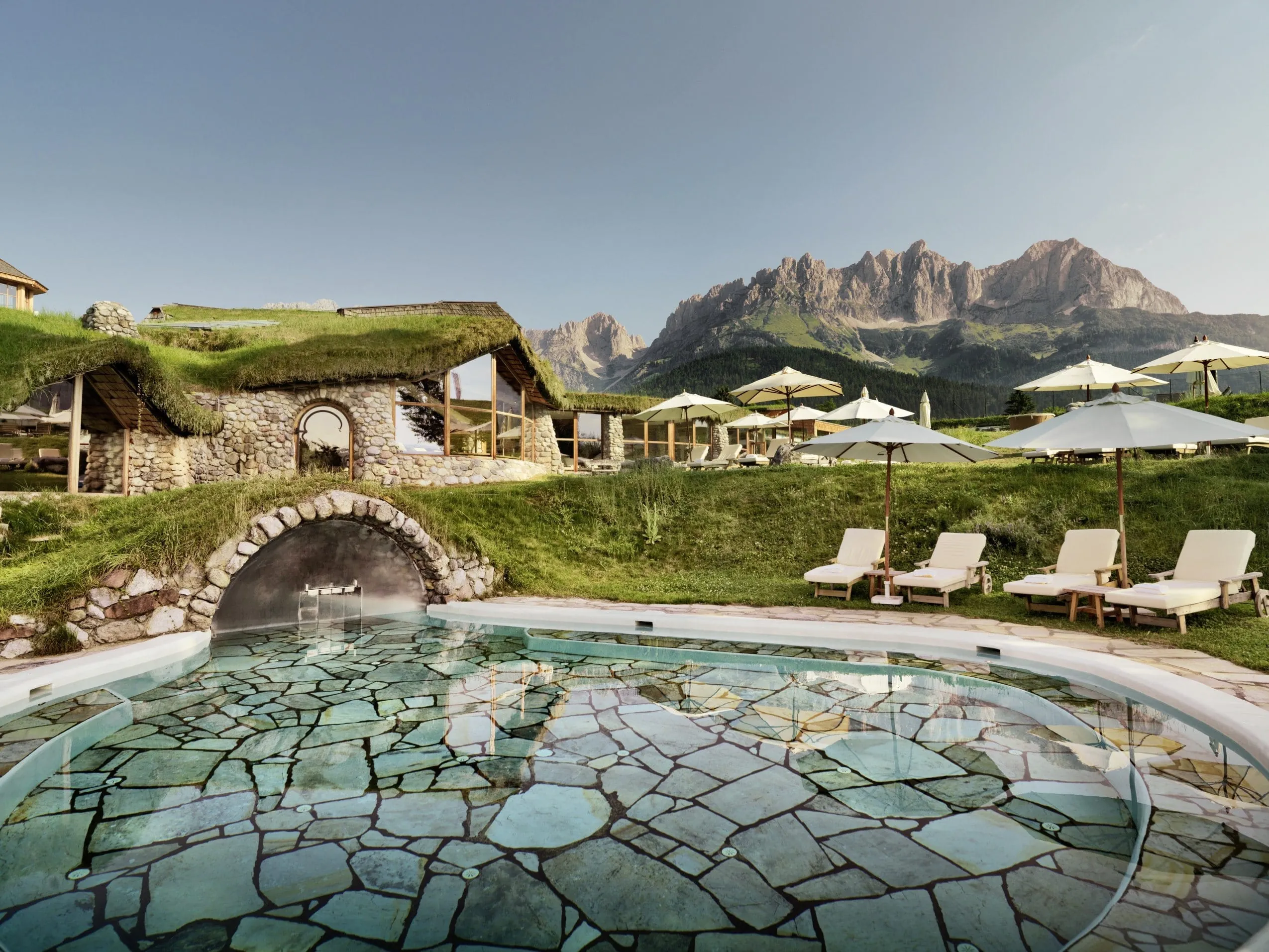 runder Outdoorpool im Bio- & Wellnessresort Stanglwirt mit verschieden gro&szlig;en t&uuml;rkisen Fliesen und Blick auf den Wilden Kaiser