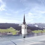 Frau steht am Beckenrand des Infinitypools auf dem Dach des Huus Quell