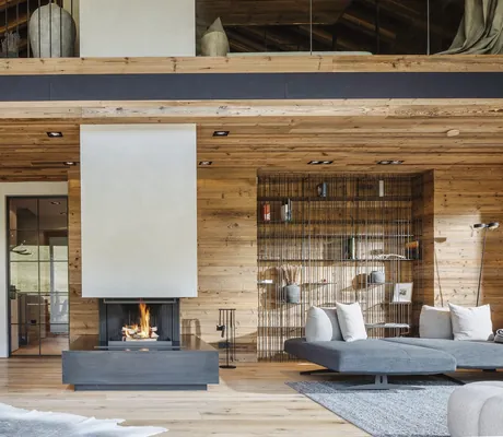 Wohnbereich im Chalet Falk mit offenem Kamin und luxuriösen Loungemöbeln