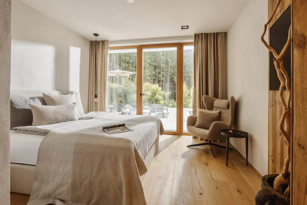 Schlafzimmer im Chalet Falk mit vorgelagerter Holzterrasse und Ohrensessel