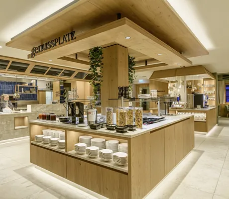 Großzügiger Buffetbereich mit Holzdesign und moderner Beleuchtung im Familotel Zauchenseehof