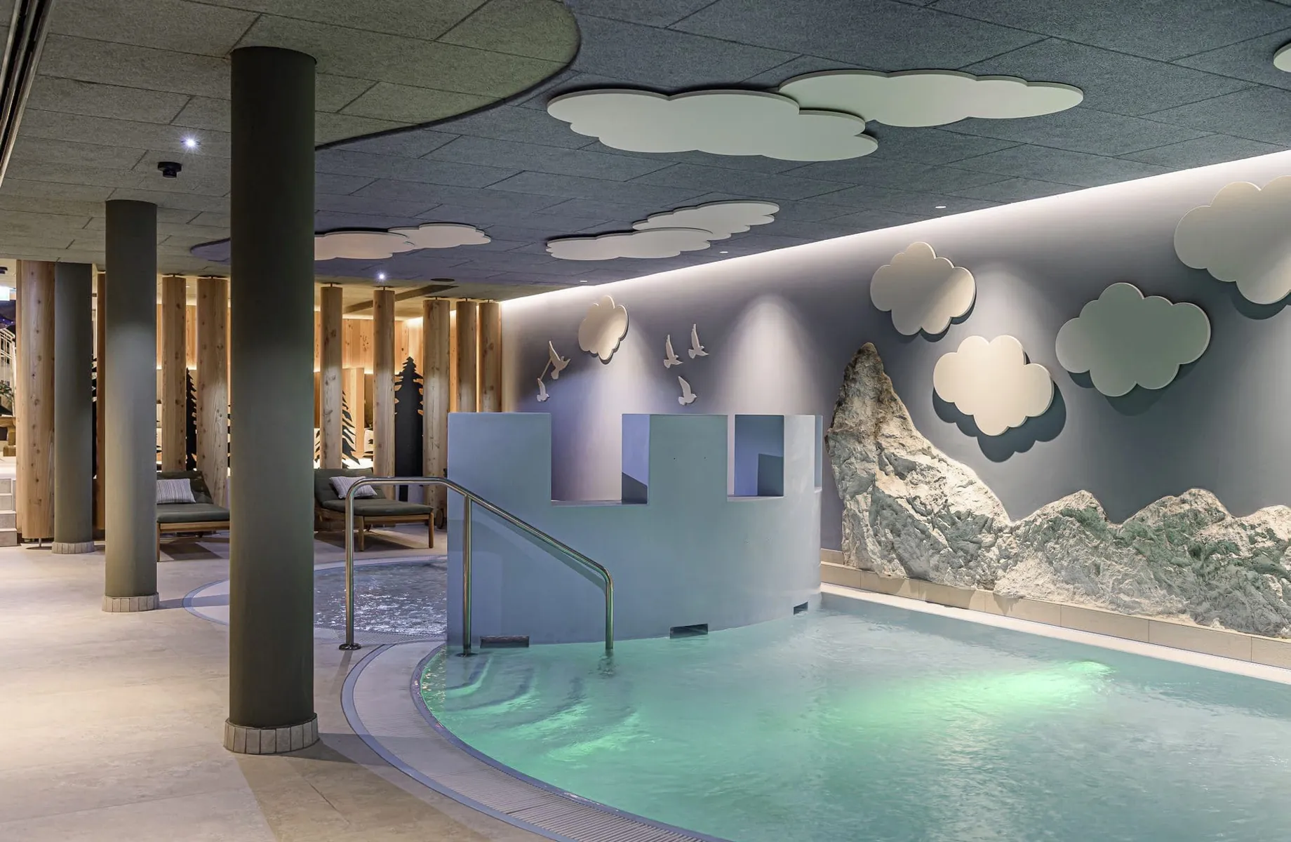 Kinderbecken, Berg- und Wolkendekorationen sowie gemütliche Liegen im Familotel Zauchenseehof