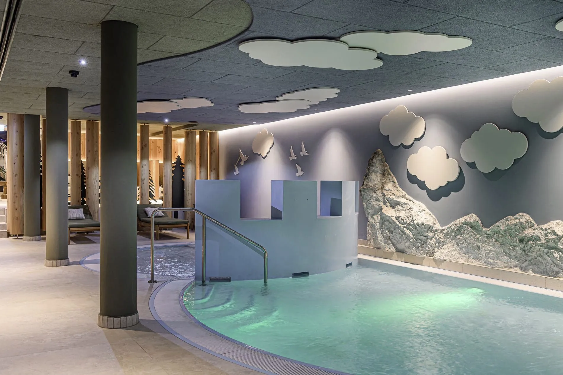 Kinderbecken, Berg- und Wolkendekorationen sowie gemütliche Liegen im Familotel Zauchenseehof