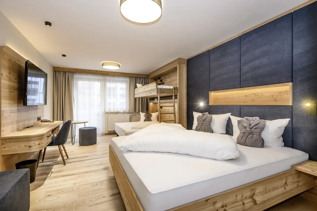 Modernes Familienzimmer mit Doppelbett, Hochbett, Holzverkleidung und großem Fenster im Familotel Zauchenseehof