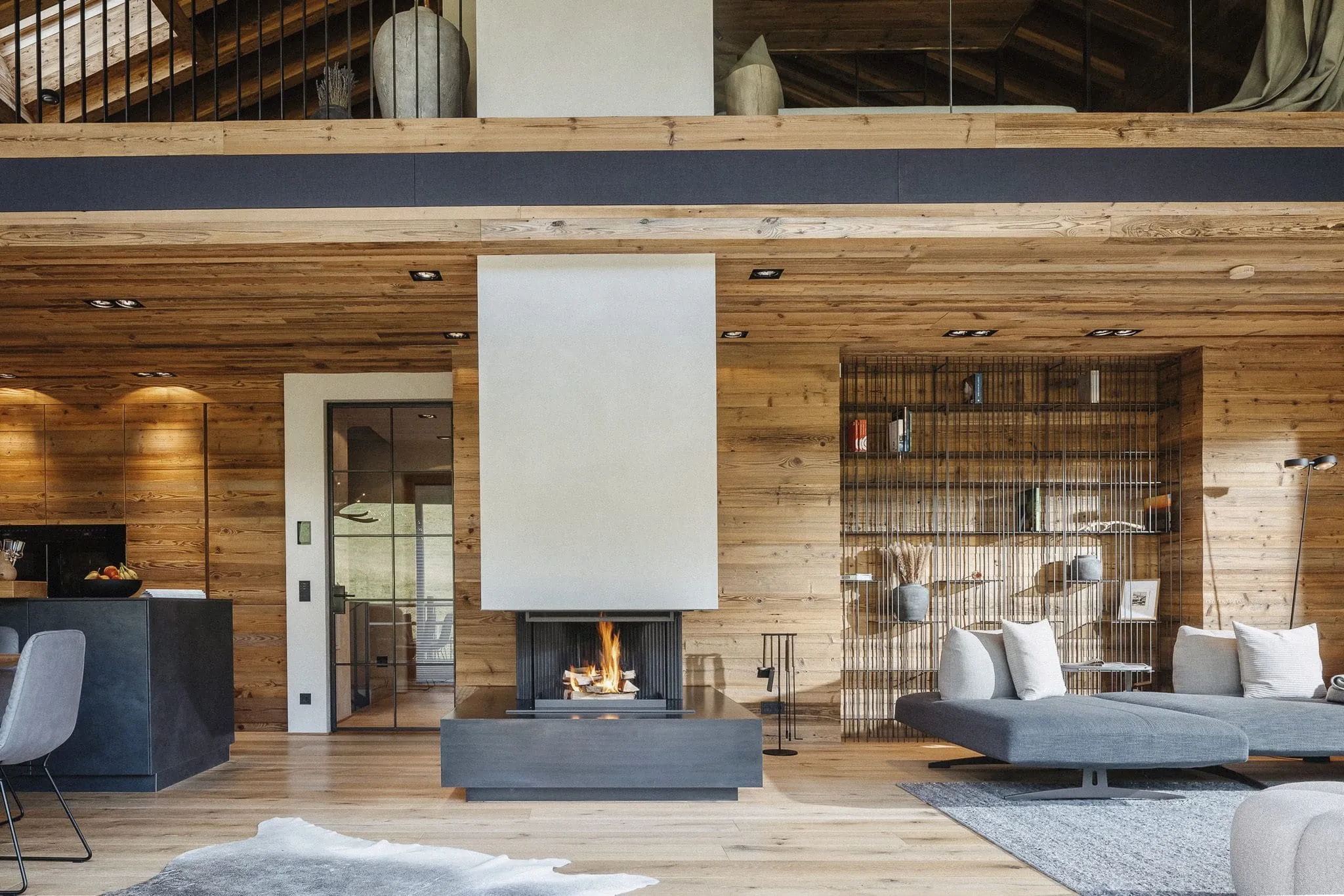 Wohnbereich im Chalet Falk mit offenem Kamin und luxuriösen Loungemöbeln