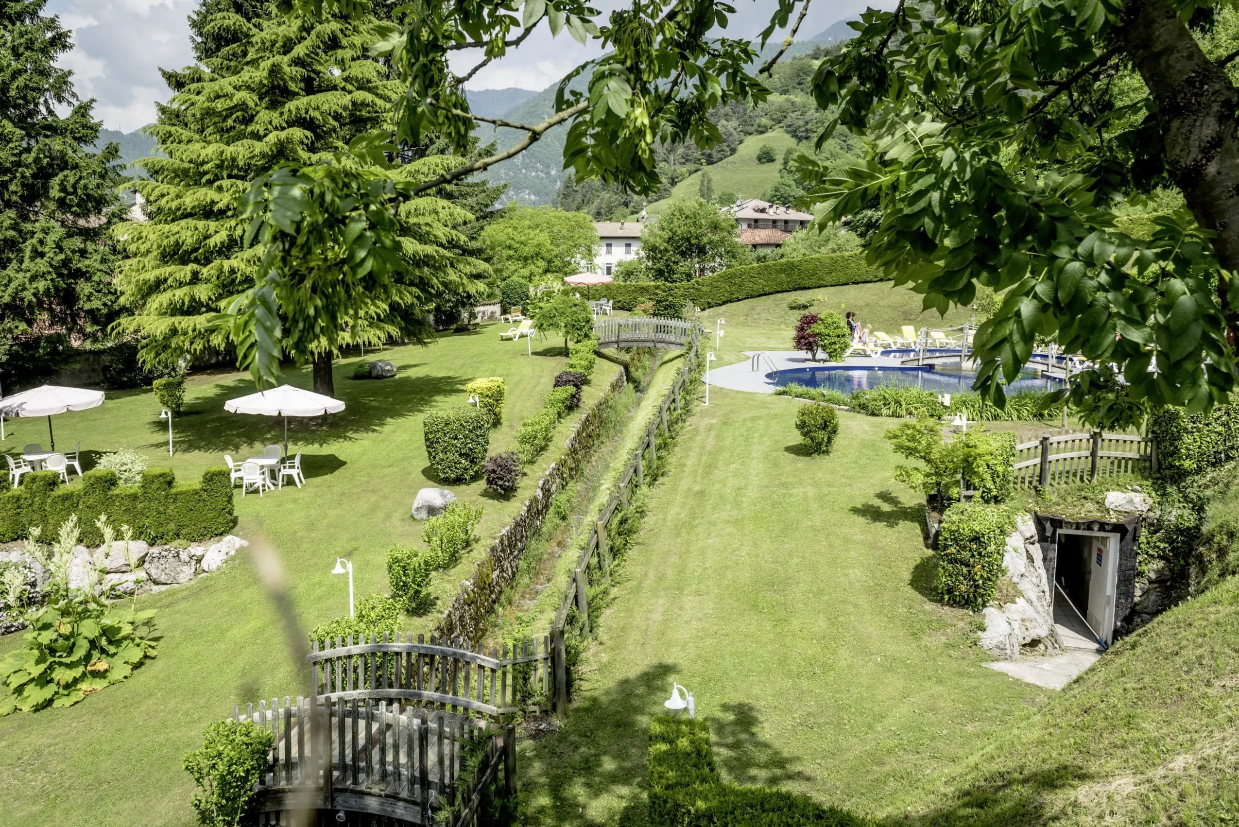 Gartenanalge im Good Life Hotel Garden mit Outdoorpool und Sitzecken unter Schirmen
