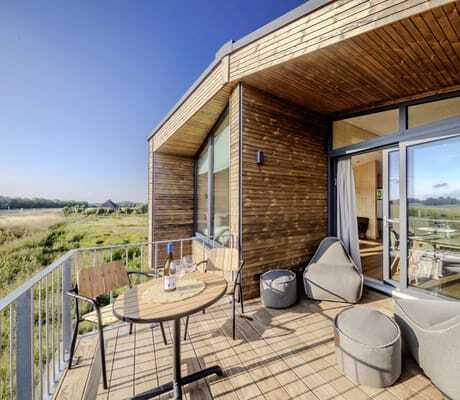 Sitzsäcke und Gartentisch auf der Holzterrasse des Ostsee Baumhaushotel