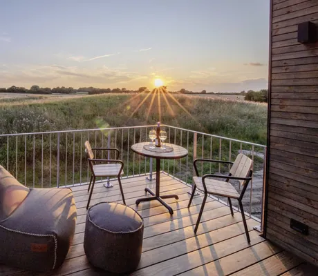Sitzsack und Gartentisch mit zwei Stühlen auf der Terrasse des Ostsee Baumhaushotel im Abendrot