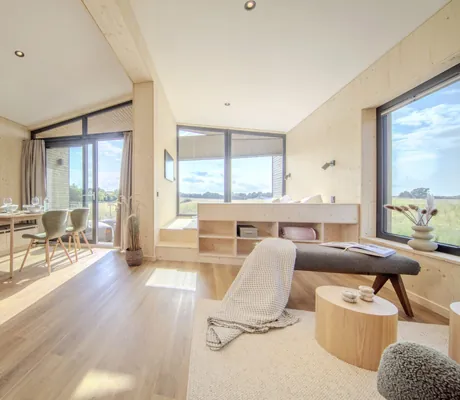 Wohnbereich im Ostsee Baumhaushotel mit Esstisch und Sitzbank mit Decke