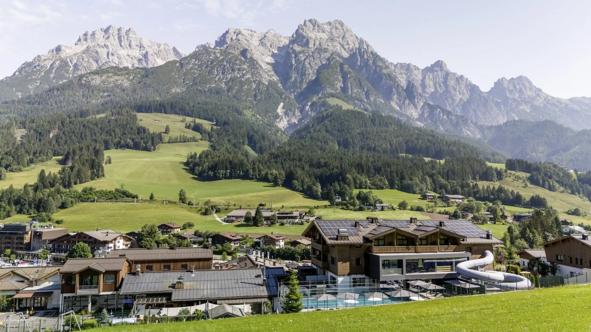 Au&szlig;enansicht des Familienbereichs des Good Life Resort Riederalm mit Familypool und Wasserrutsche