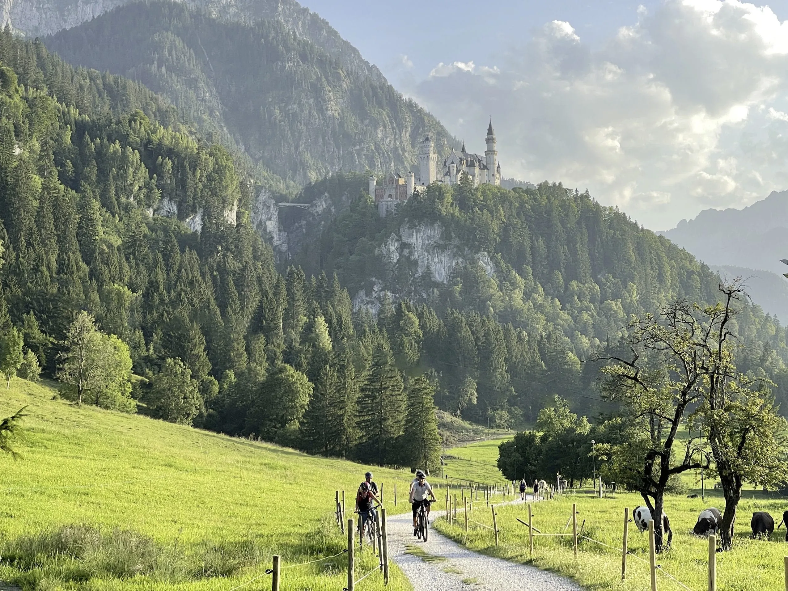 Wanderer und Radfahrer in der unmittelbaren Umgebung des Hotel Sommer mit Schloss Neuschwanstein im Hintergrund