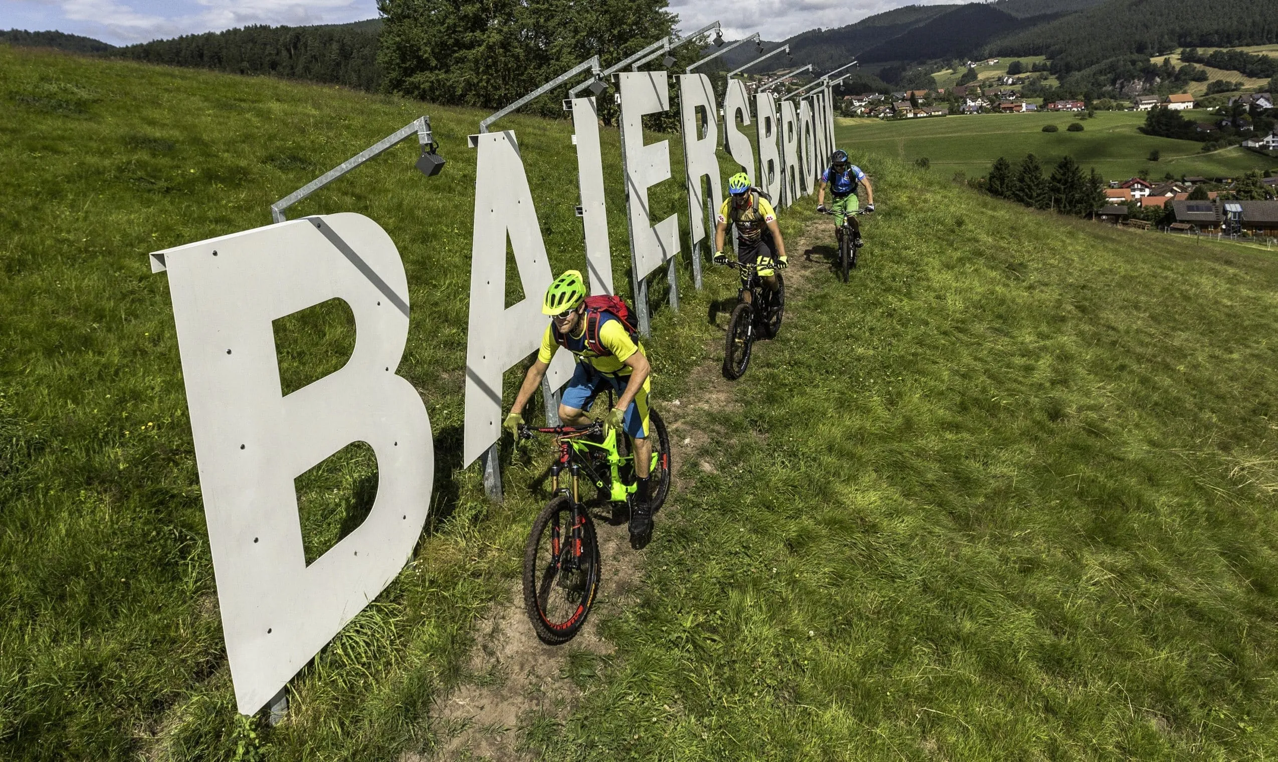 Biker fahren auf einem Trail entlang der gro&szlig;er Buchstaben der Stadt Baiersbronn in der N&auml;he des Wellnesshotels Tanne