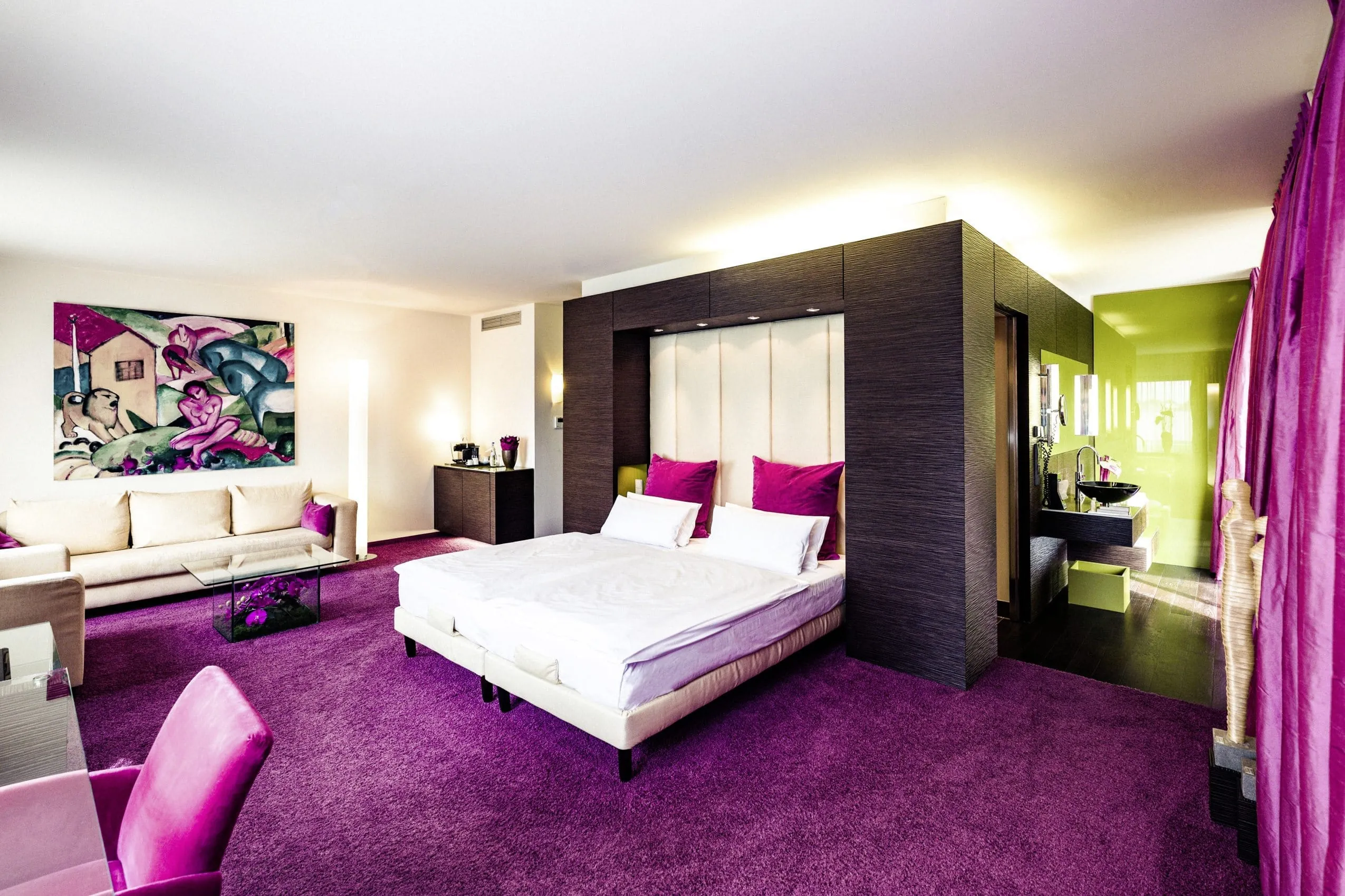 Stilvoll eingerichtete Suite im Hotel Der Blaue Reiter mit pinken und gr&uuml;nen Farbakzenten