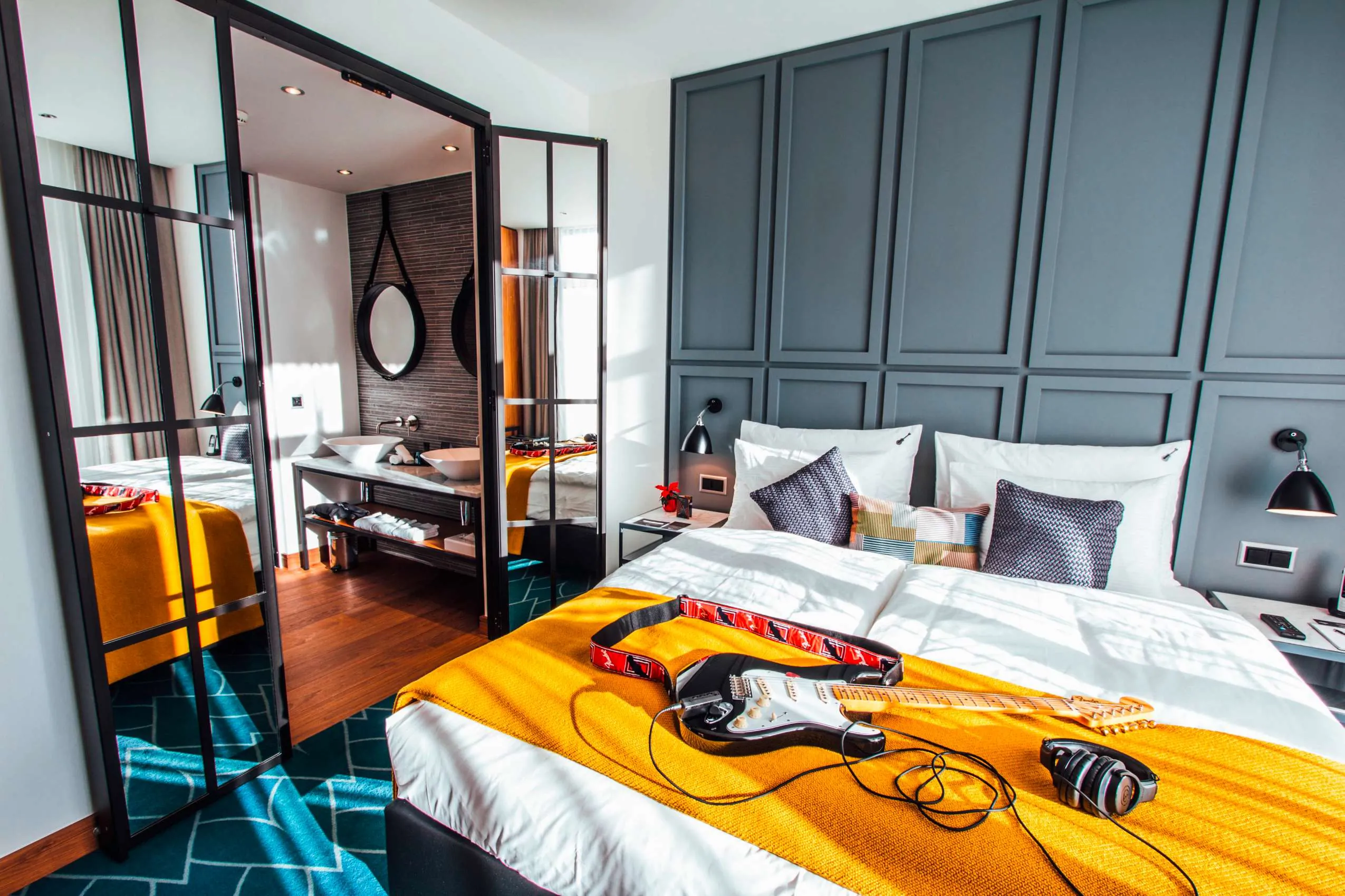 Doppelzimmer mit gelber Tagesdecke und Gitarre im Hard Rock Hotel Davos
