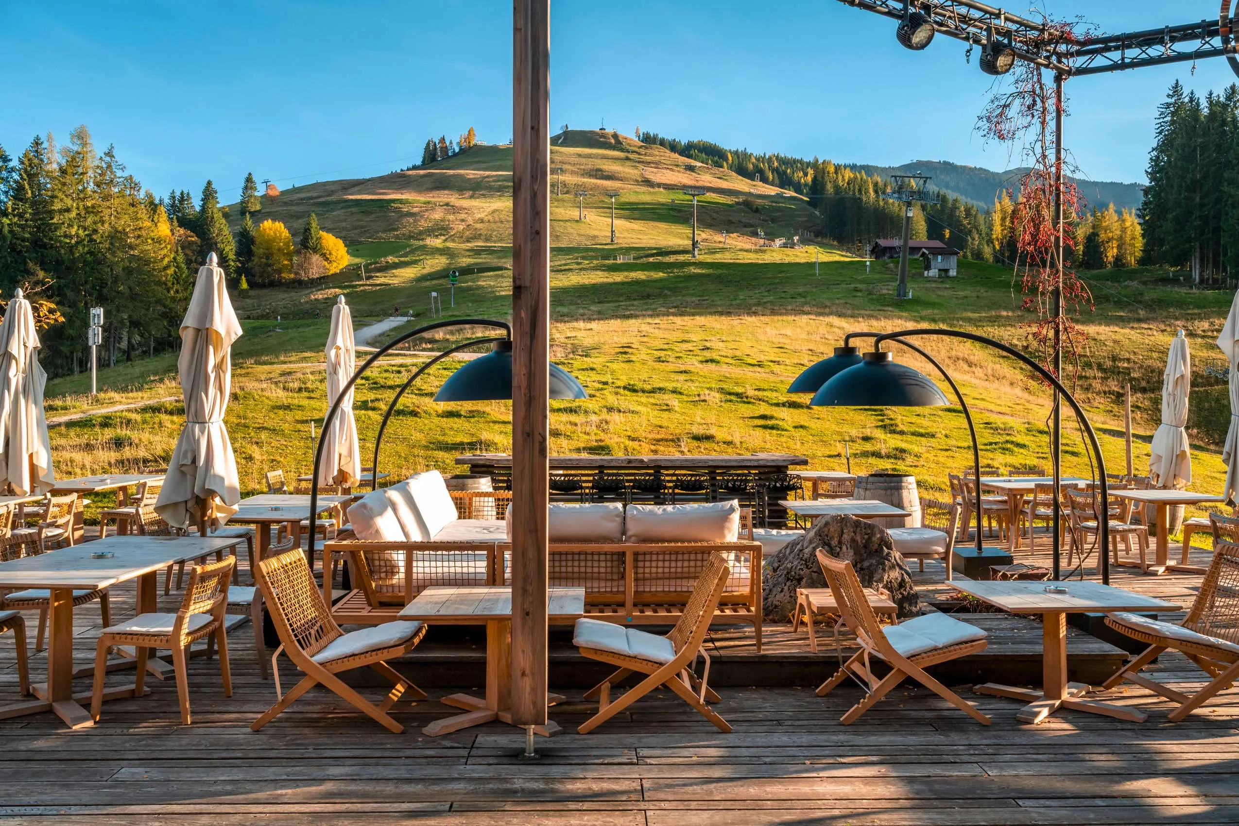 Blick von der Terrasse auf die Wiese vor dem Holzhotel Forsthofalm