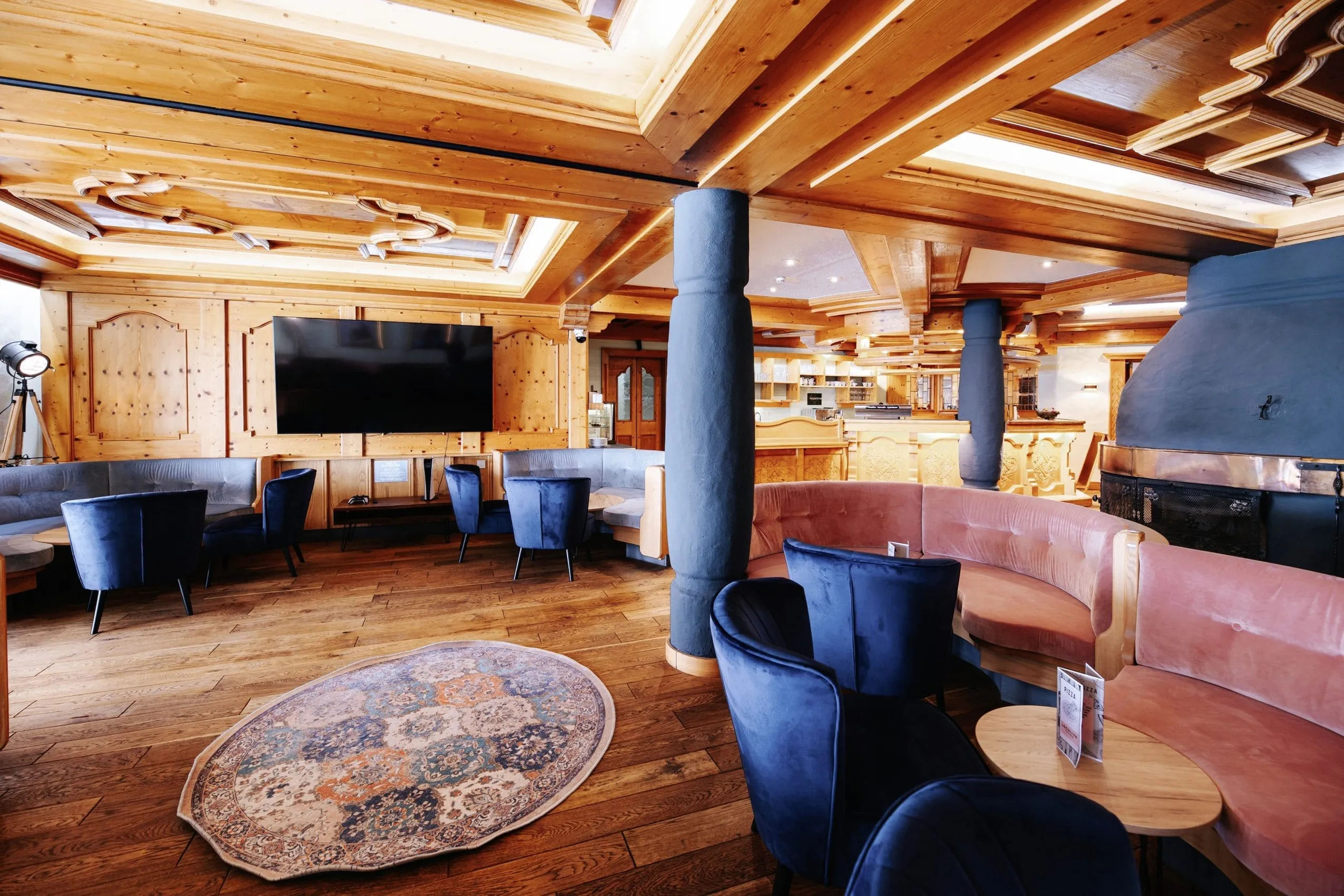 Modern gestylte Bar mit rosa und blauen Polsterm&ouml;beln im LechLife Travelhouse