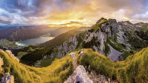 Sonnenuntergang über dem Achensee mit Blick auf das Rofangebirge, grüne Wiesen und felsige Berglandschaft in der Nähe der Wellnessresidenz Alpenrose – Der Alpine Kraftplatz