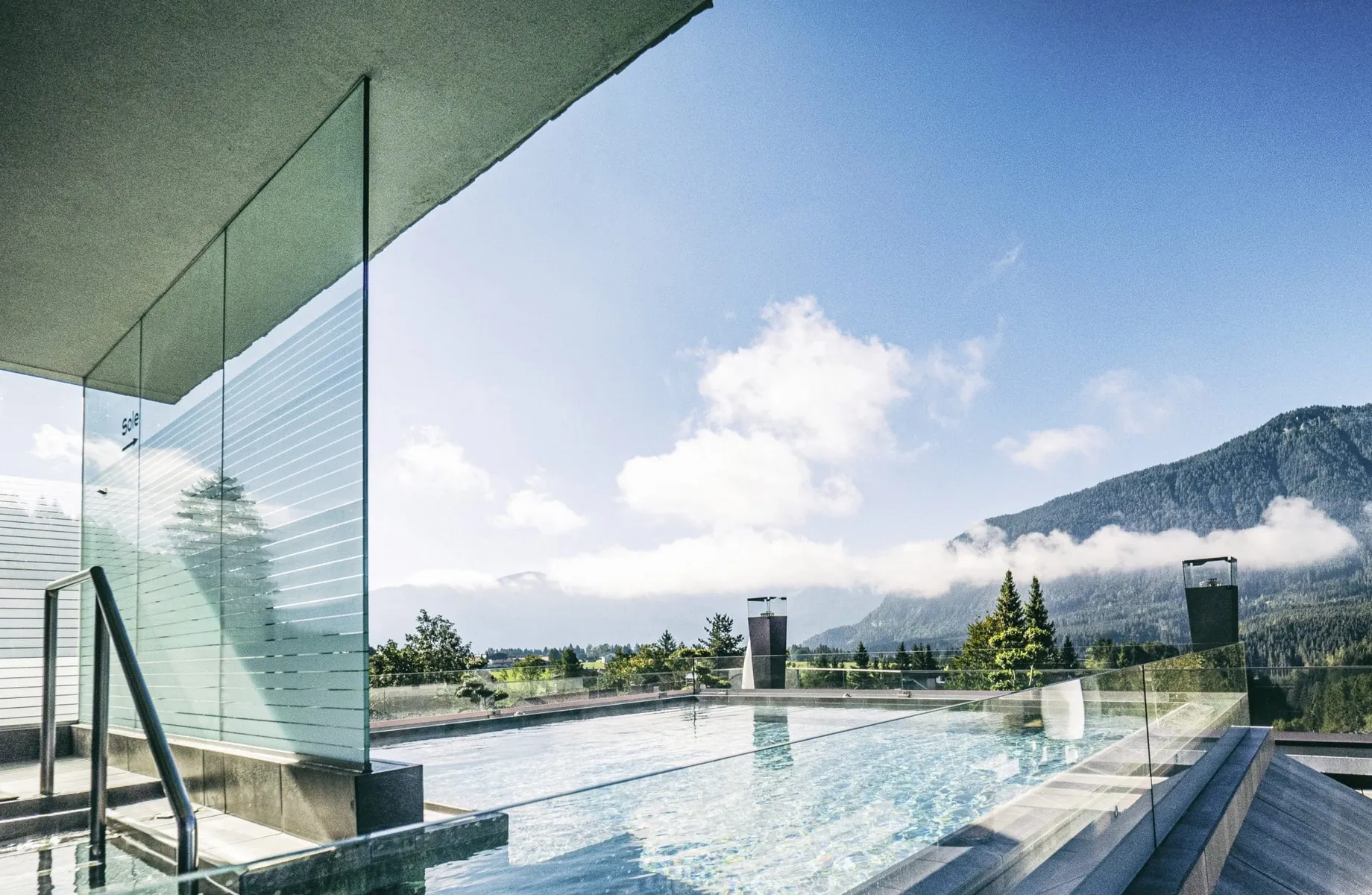 Rooftop-Pool der Wellnessresidenz Alpenrose mit Glasabtrennung und Blick auf die umliegende Berglandschaft