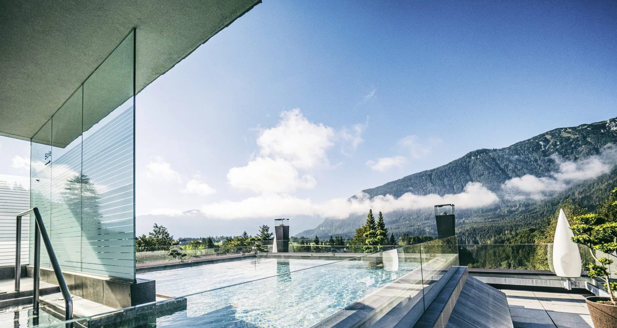 Rooftop-Pool der Wellnessresidenz Alpenrose mit Glasabtrennung und Blick auf die umliegende Berglandschaft