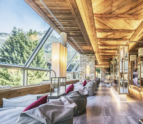 Lichtdurchfluteter Ruheraum der Wellnessresidenz Alpenrose mit modernem Holzdesign, Liegen und Panoramablick
