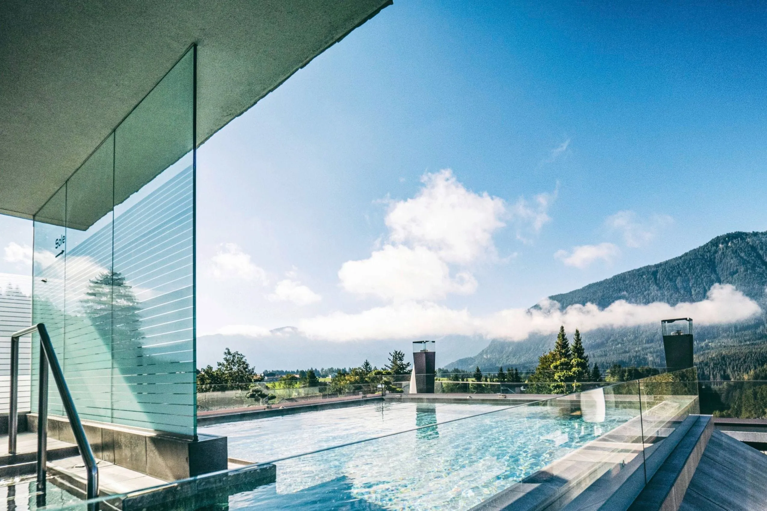 Rooftop-Pool der Wellnessresidenz Alpenrose mit Glasabtrennung und Blick auf die umliegende Berglandschaft
