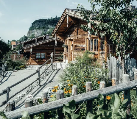 Sommerliche Außenansicht eines der Alpzitt-Chalets mit Holzfassade und Bergkulisse im Hintergrund