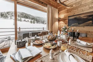 Liebevoll gedeckter Frühstückstisch im Chalet Falk | luxury mountain hideaway mit Holzinterieur und Panoramablick auf eine verschneite Landschaft