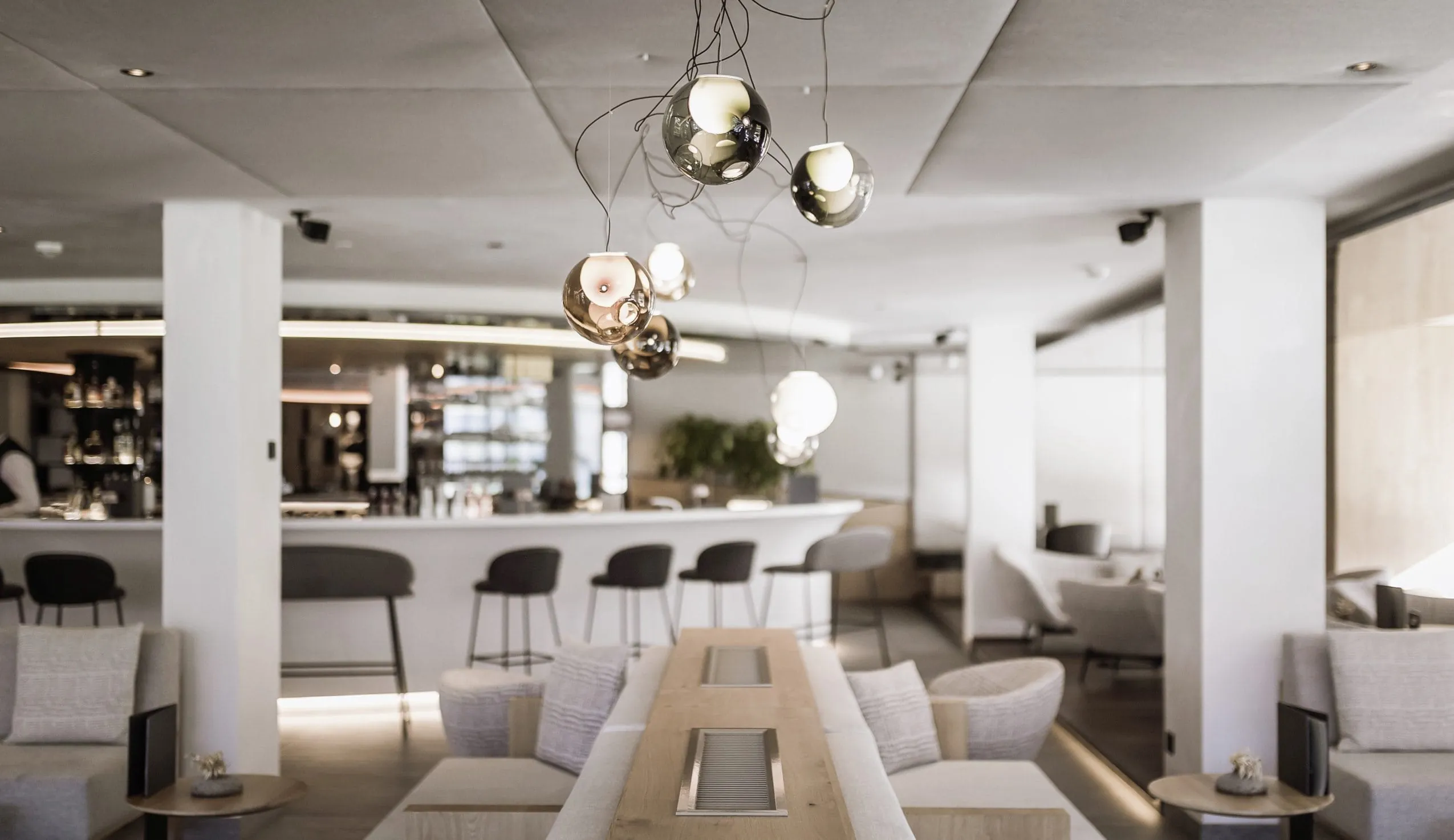 Stylische Bar im Hotel Winkler mit runder Theke und Kugellampen in der Front