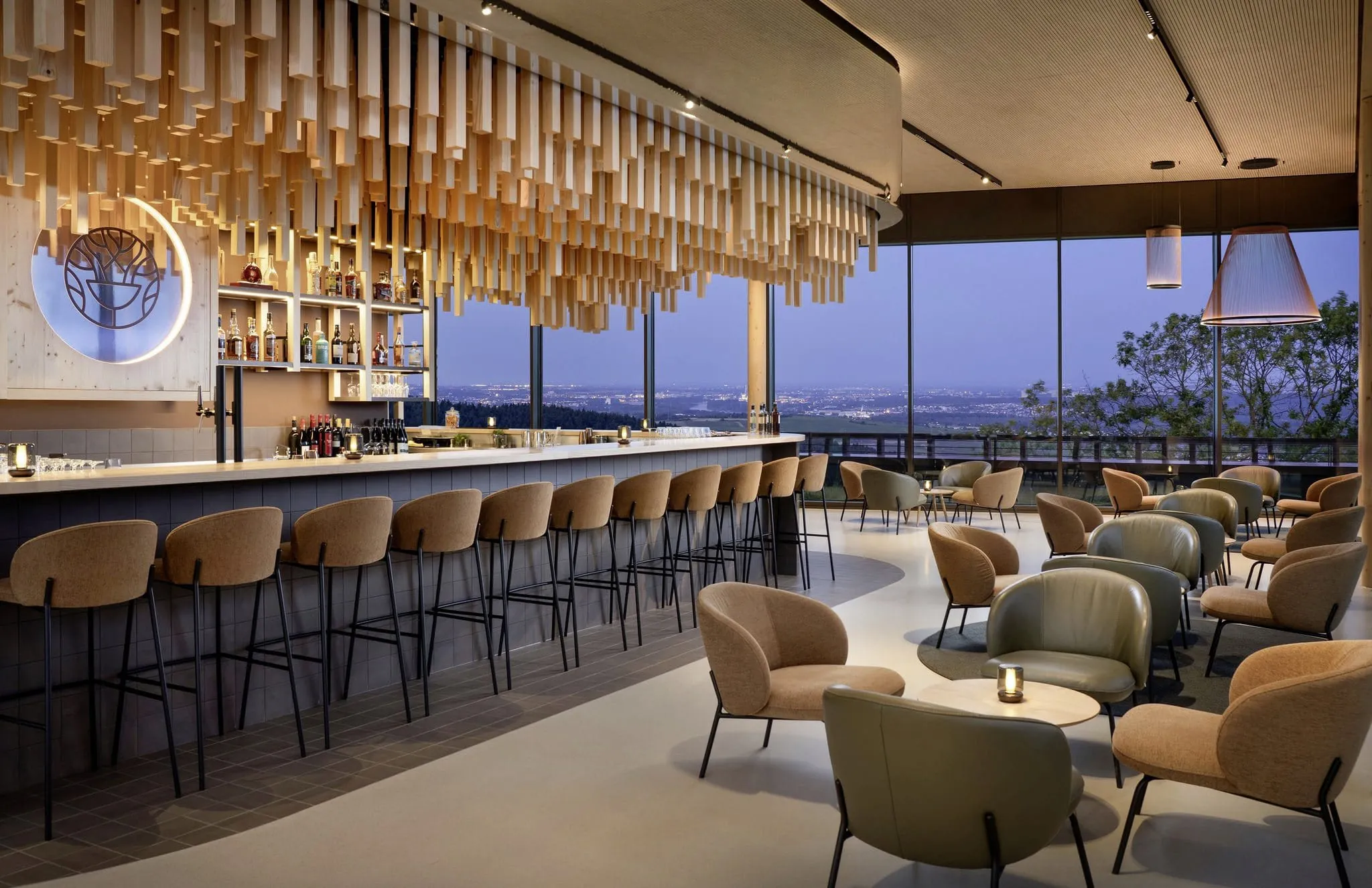 Hotelbar im WALD.WEIT Rheingau Hotel & Retreat mit Holzstrelen &uuml;ber der Theke und gro&szlig;em Panoramafenster