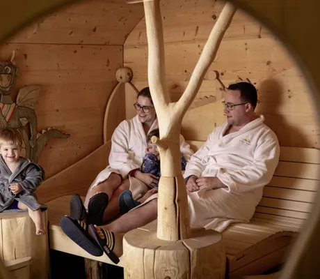 Familie entspannt in einer Holzsauna mit kindgerechter Deko im Familotel Elldus Resort