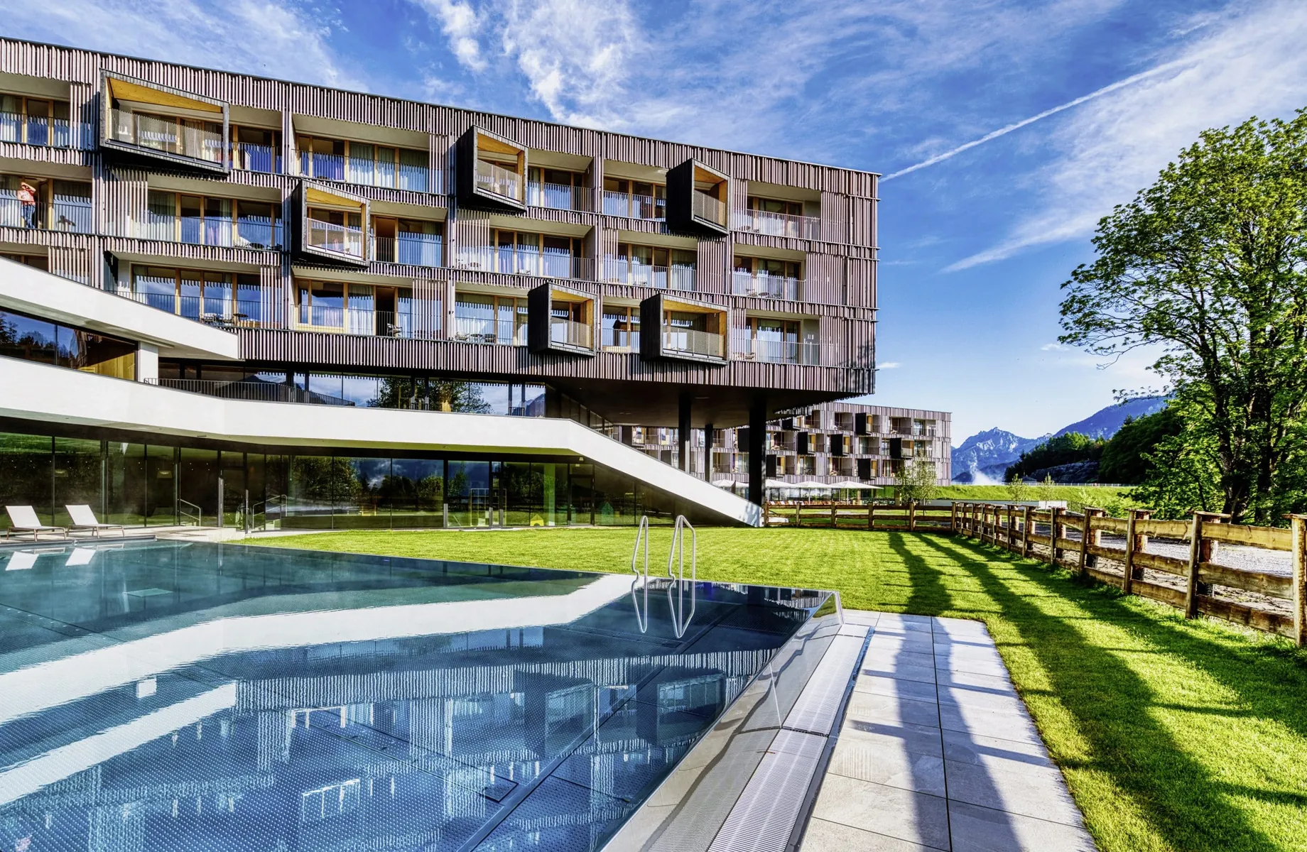 Außenansicht des Falkensteiner Family Hotel Montafon mit moderner Fassade, Pool und Bergpanorama