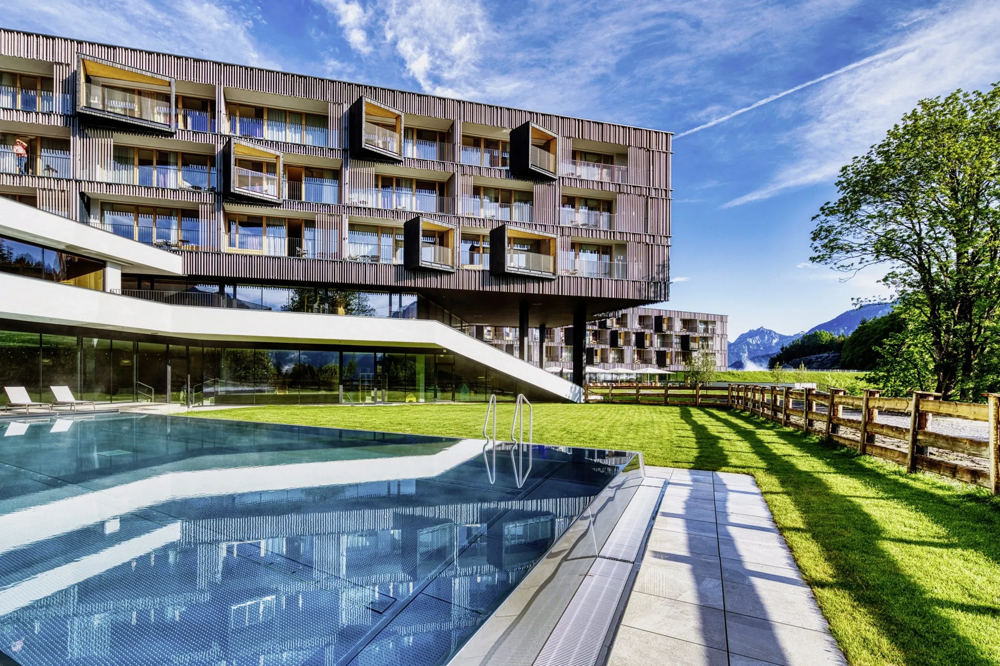 Außenansicht des Falkensteiner Family Hotel Montafon mit moderner Fassade, Pool und Bergpanorama