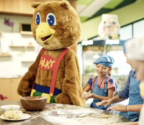 Kinder beim Backkurs im Falkensteiner Family Hotel Montafon mit Maskottchen Falky in der Küche