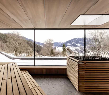 Sauna im Falkensteiner Family Hotel Montafon mit Panoramafenstern und Blick auf die verschneiten Berge