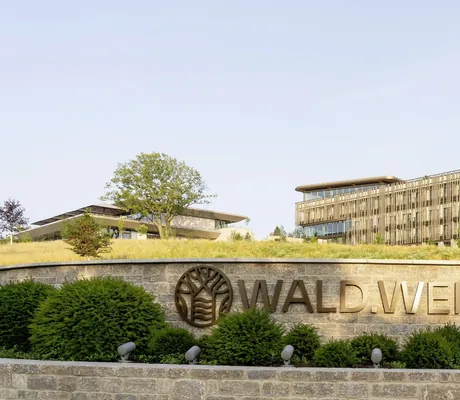 Außenaufnahme des WALD.WEIT mit Außenmauer mit Hotelnamen