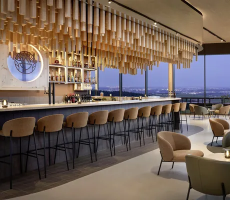 Hotelbar im WALD.WEIT mit Holzstrelen über der Theke und großem Panoramafenster
