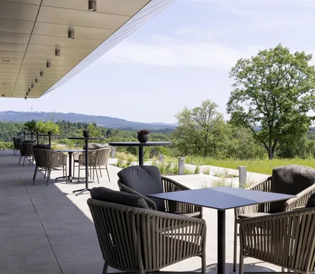 Tagungsterrasse im WALD.WEIT mit Korbstühlen und weitem Blick ins Grüne