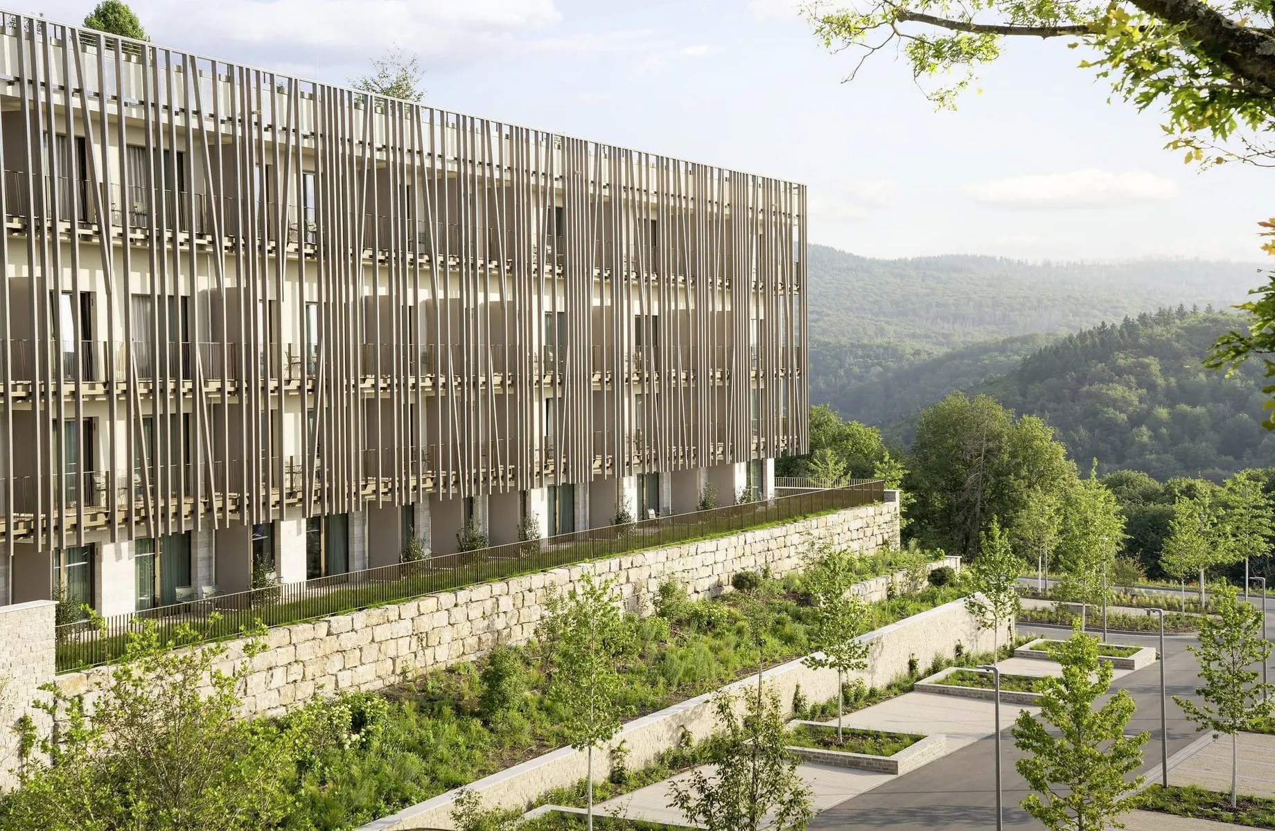 mit Holzstelen verkleidete Fassade des WALD.WEIT mit Blick auf die Wälder