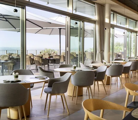 Restaurant im WALD.WEIT mit großen runden Holztischen und vorgelagerter Terrasse