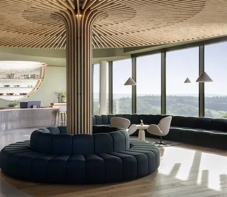 Rezeption im WALD.WEIT großem runden Holzelemet in der Mitte umgeben von einem runden Sofa