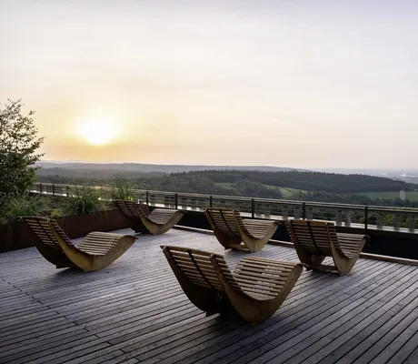 Schaukelliegen aus Holz auf der Dachterrasse des WALD.WEIT und Blick in den Sonnenuntergang