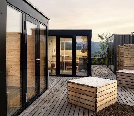 Rooftop-Saunabereich im WALD.WEIT mit kubusartigen Saunawürfeln und Dusche hinter Holzwand